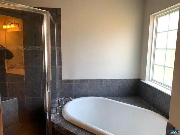 a bath tub sitting in a bathroom next to a window