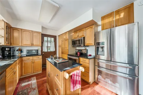 a kitchen with stainless steel appliances granite countertop a refrigerator stove top oven and sink