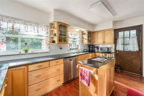a kitchen with granite countertop a sink and a stove