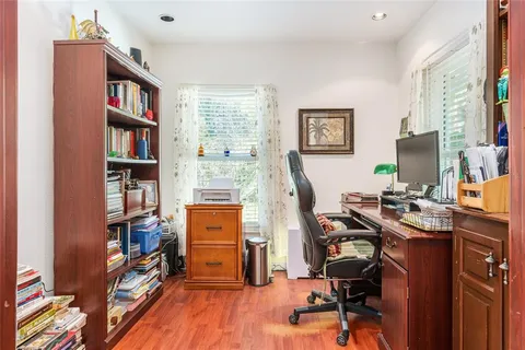 a view of a workspace with bookshelf and a window