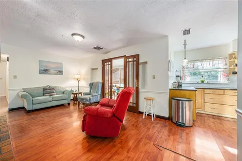 a living room with furniture and a wooden floor