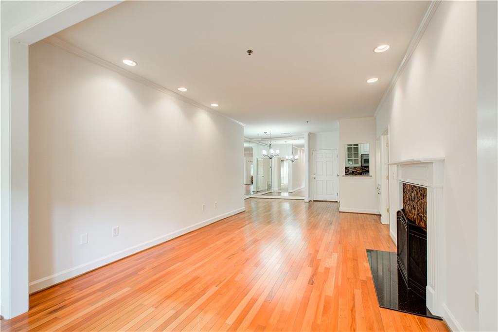 2865 Lenox Road Northeast, Unit 102 Atlanta, GA 30324 - Photo 17 of 35 a view of an empty room with wooden floor and a fireplace