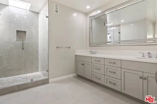 a bathroom with a shower sink and mirror
