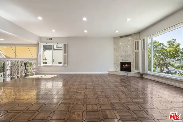 a view of an empty room with a fireplace and a window