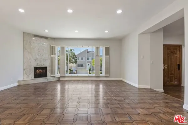 a view of an empty room with a fireplace and a window