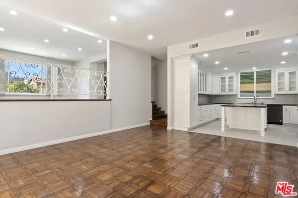 a view of kitchen with stainless steel appliances granite countertop cabinets and wooden floor