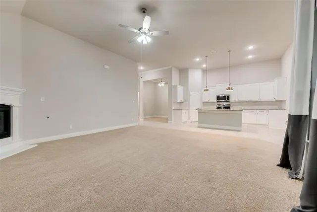 a view of kitchen with refrigerator and white cabinets