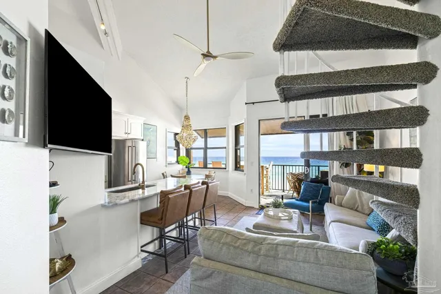 a living room with furniture a flat screen tv and a floor to ceiling window