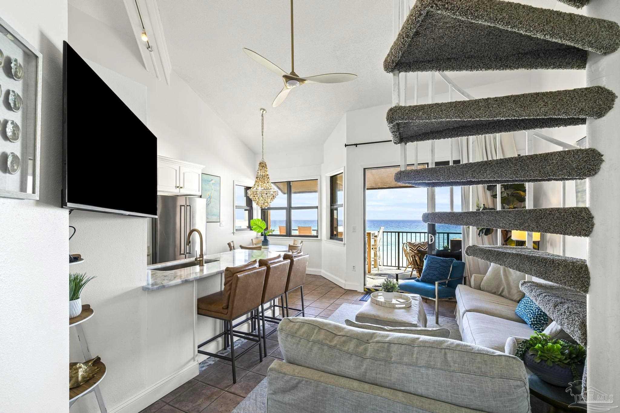 1199 Fort Pickens Road, Unit 402 Pensacola Beach, FL 32561 - Photo 5 of 12 a living room with furniture a flat screen tv and a floor to ceiling window