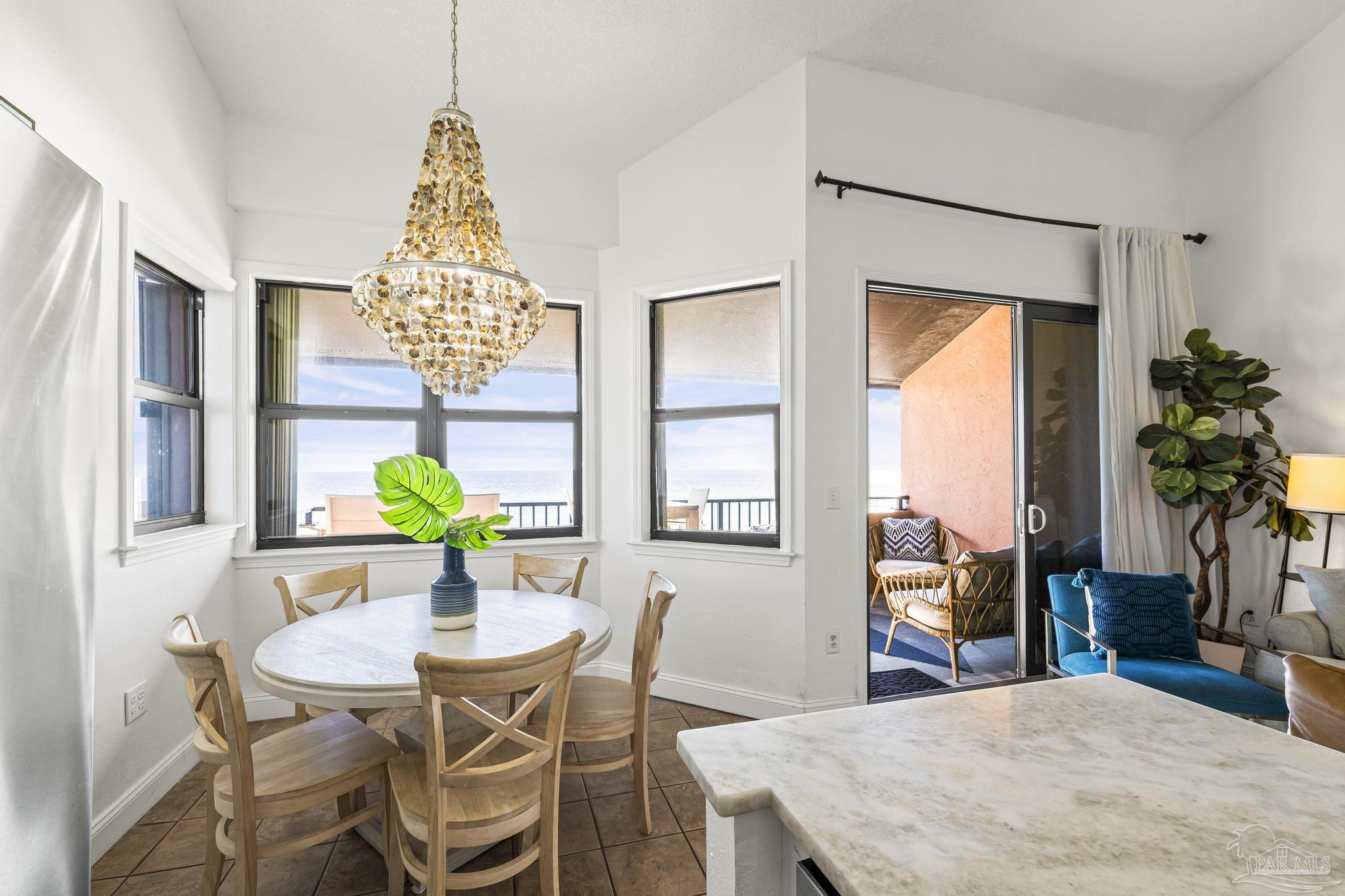 1199 Fort Pickens Road, Unit 402 Pensacola Beach, FL 32561 - Photo 6 of 12 a view of a dining room with furniture and a potted plant