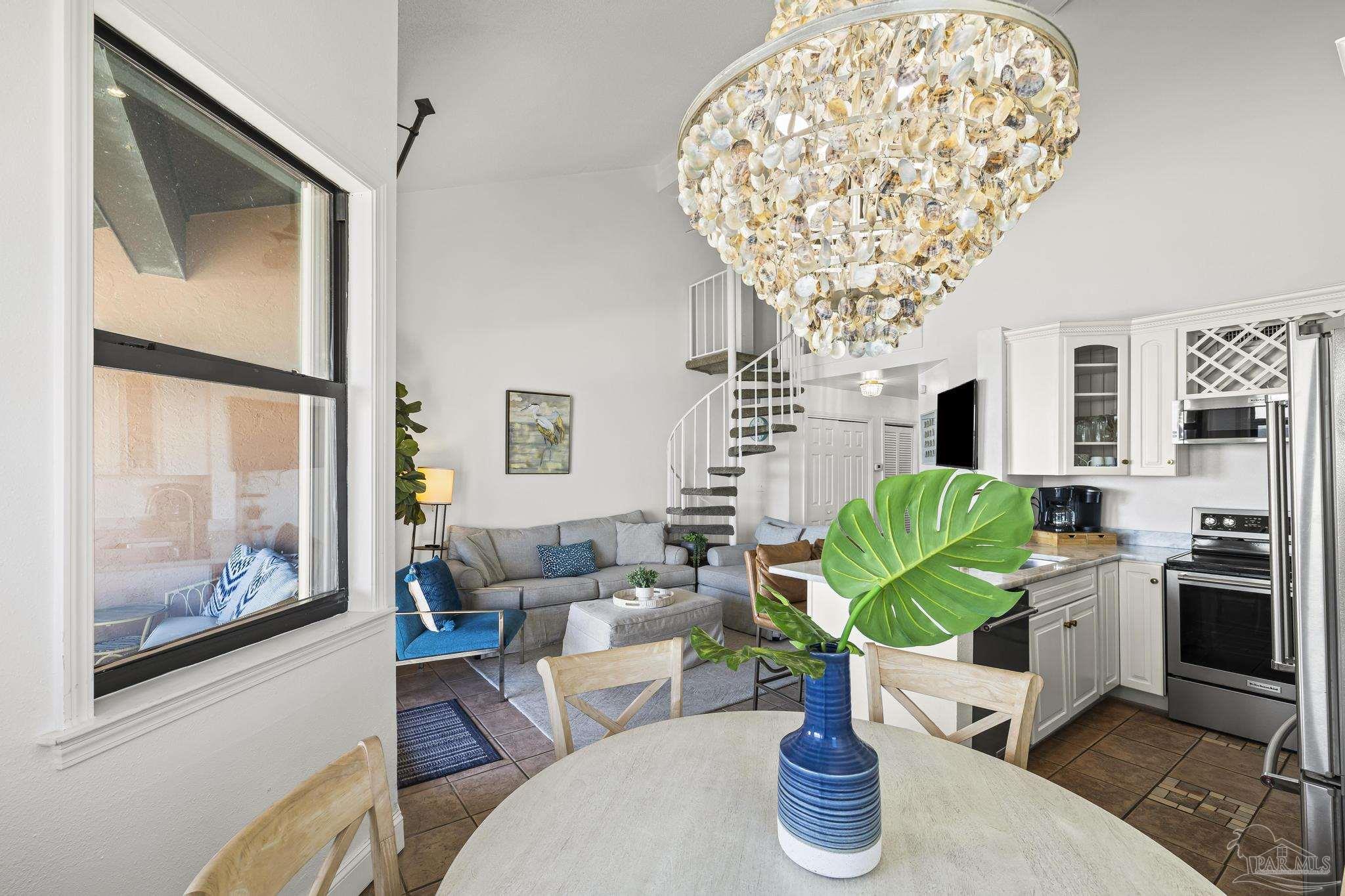 1199 Fort Pickens Road, Unit 402 Pensacola Beach, FL 32561 - Photo 7 of 12 a living room with furniture a chandelier and a fireplace