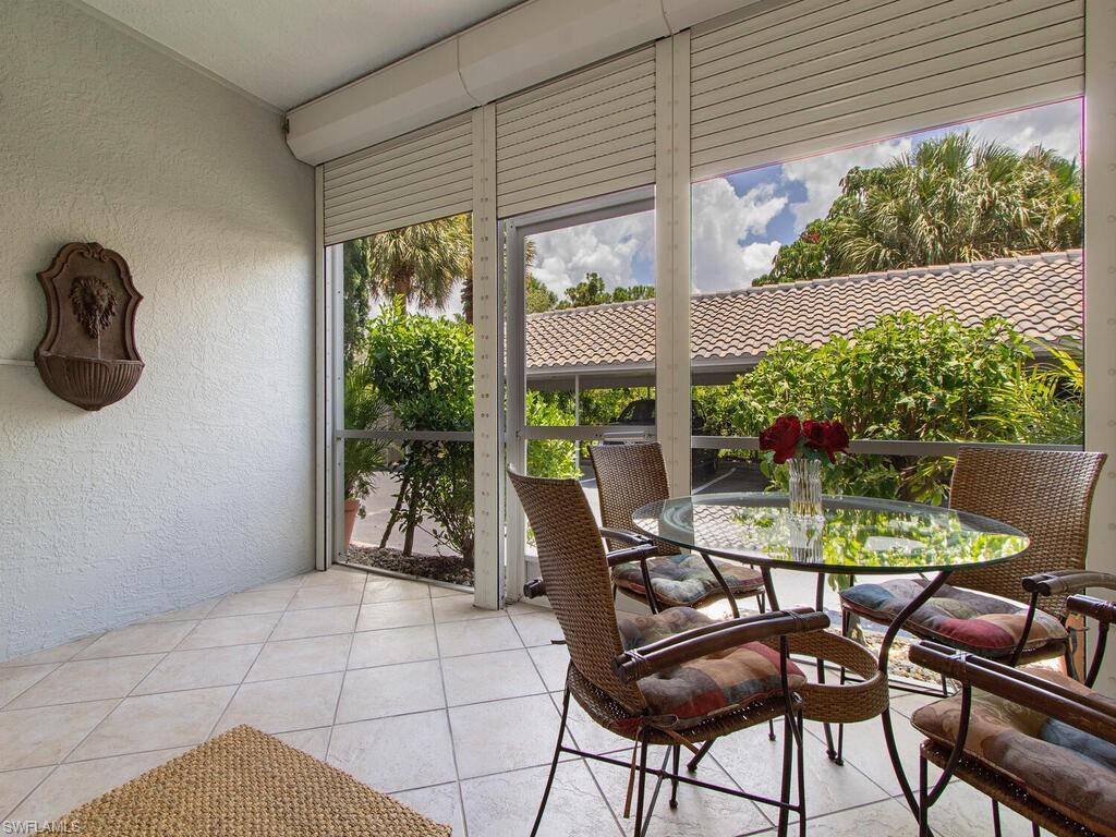 519 Roma Court, Unit 3101 Naples, FL 34110 - Photo 11 of 12 a patio with table and chairs and potted plants