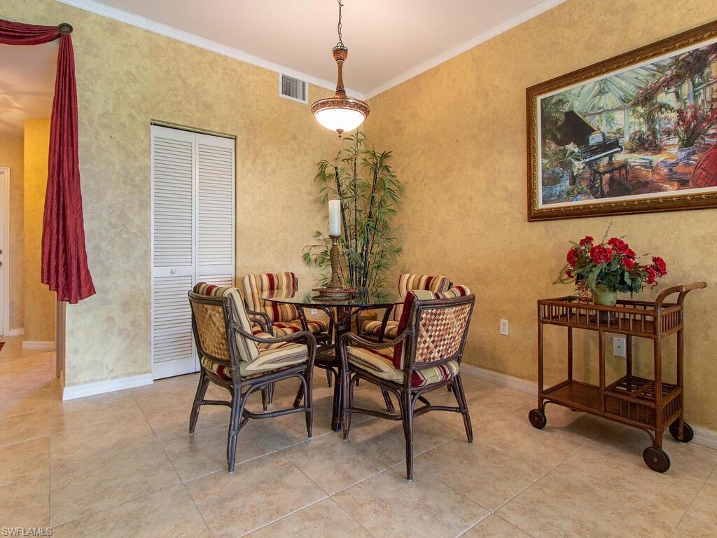 519 Roma Court, Unit 3101 Naples, FL 34110 - Photo 3 of 12 a dining room with furniture and a chandelier