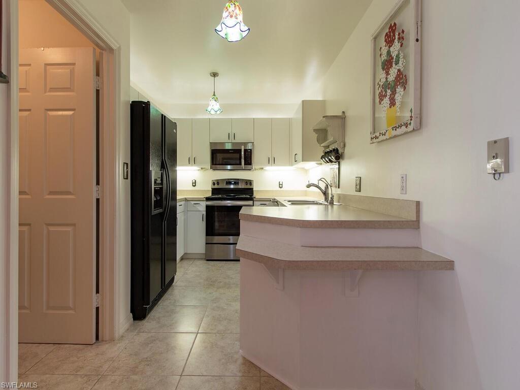 519 Roma Court, Unit 3101 Naples, FL 34110 - Photo 4 of 12 a kitchen with stainless steel appliances a refrigerator and a stove