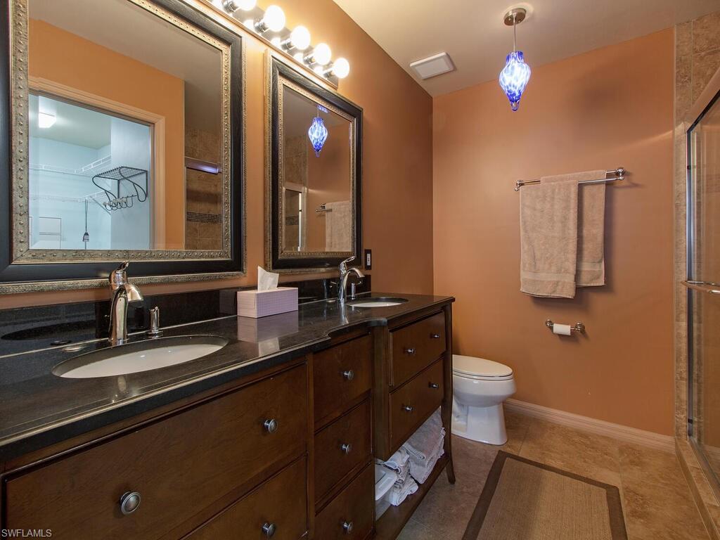 519 Roma Court, Unit 3101 Naples, FL 34110 - Photo 6 of 12 a bathroom with a sink a toilet a mirror and shower