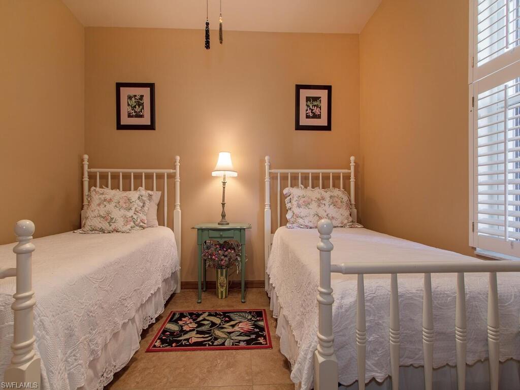 519 Roma Court, Unit 3101 Naples, FL 34110 - Photo 7 of 12 a bedroom with a bed and wooden floor