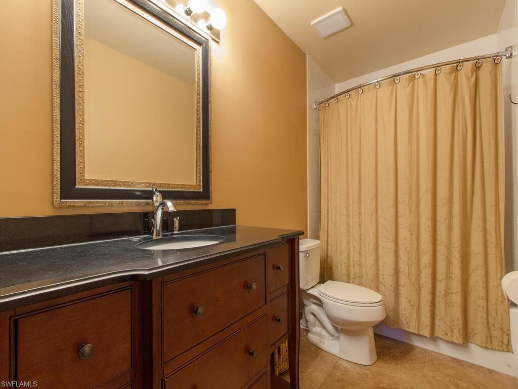 519 Roma Court, Unit 3101 Naples, FL 34110 - Photo 8 of 12 a bathroom with a toilet a sink and mirror