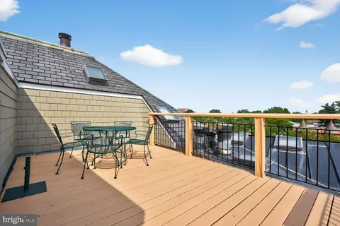 a roof deck with table and chairs