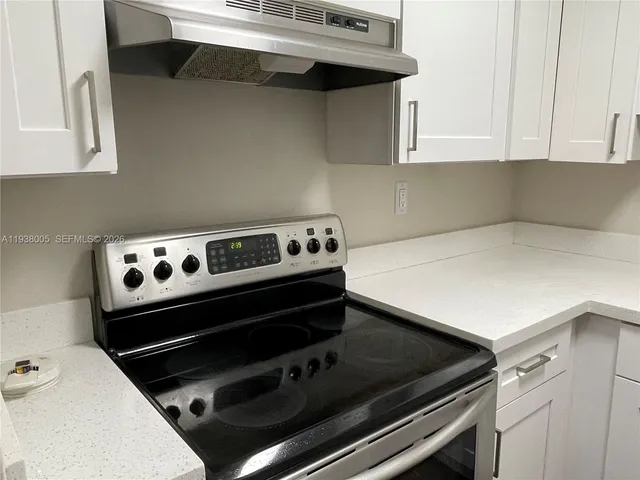 a kitchen with a stove and white cabinets