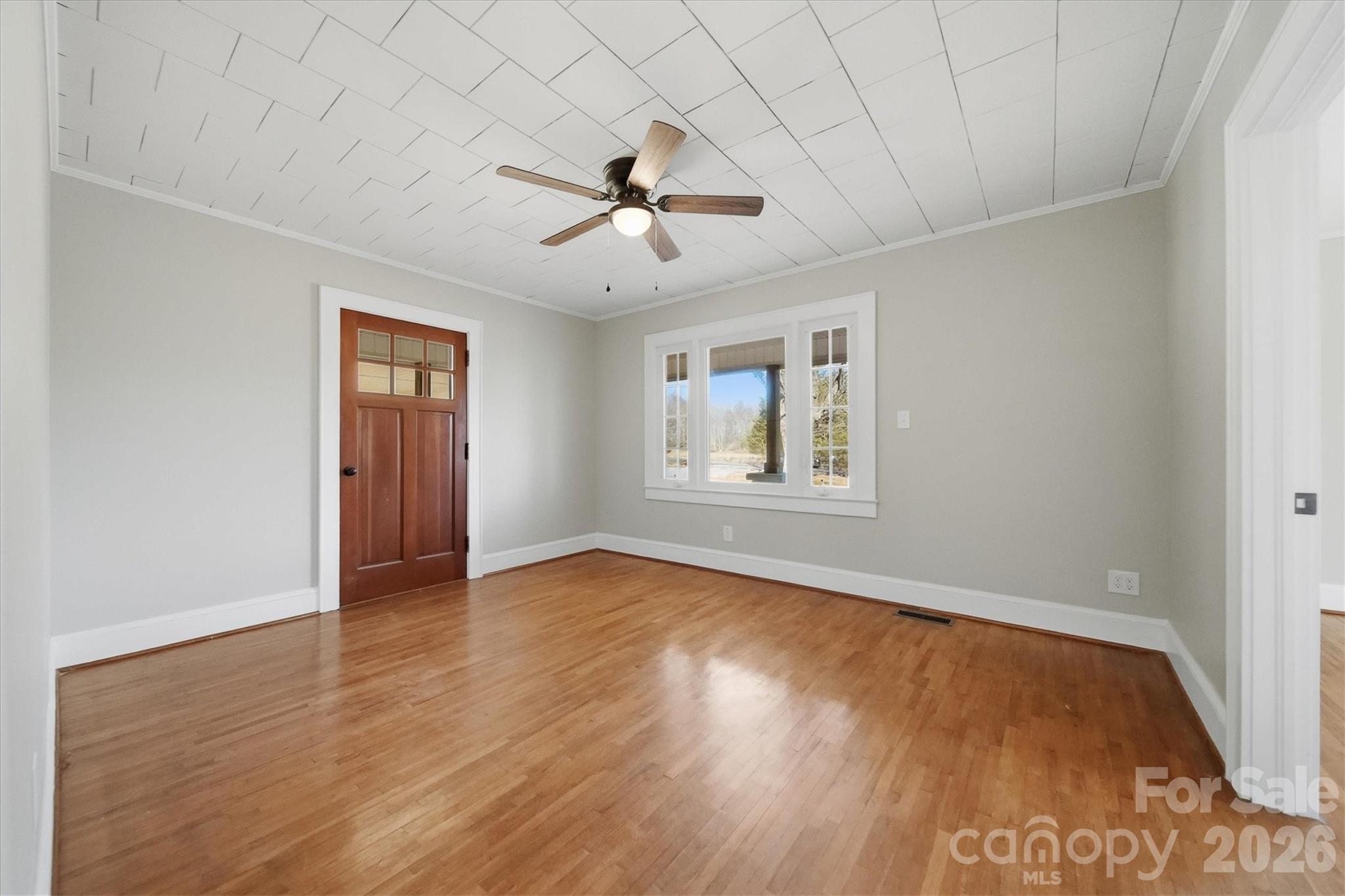 4141 Laney Road Maiden, NC 28650 - Photo 8 of 47 an empty room with wooden floor chandelier fan and windows