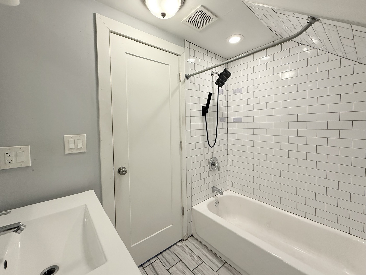 2815 West 25th Street Chicago, IL 60623 - Photo 23 of 27 a bathroom with a tub a sink a window and a shower
