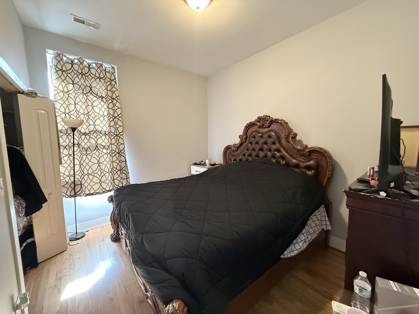 2815 West 25th Street Chicago, IL 60623 - Photo 6 of 27 a bed sitting in a bedroom next to a window with tv