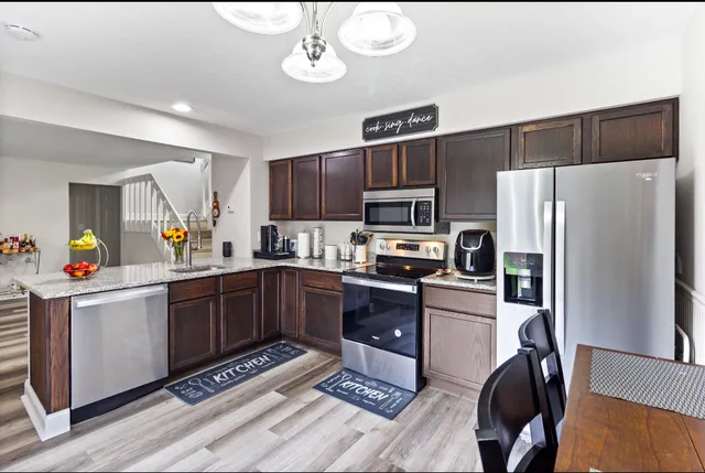 a kitchen with refrigerator cabinets and wooden floor