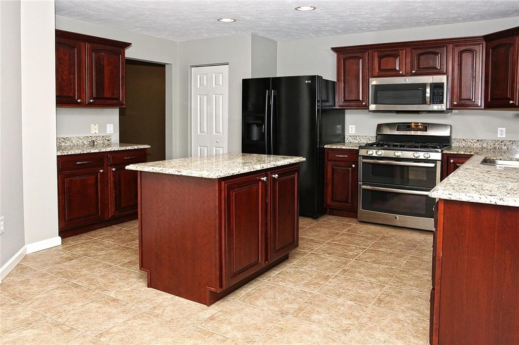 9780 Grosick Road Pittsburgh, PA 15237 - Photo 5 of 22 Large Kitchen with center island with updated granite countertops. New Stainless Steel Double Oven with a convection feature. Gleaming cherry cabinetry. Deep double sink with Disposal. LG Fridge and Dishwasher. Roomy pantry. Ceramic Tile Flooring.
