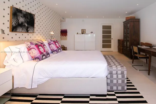 a bedroom with a large bed and flat screen tv