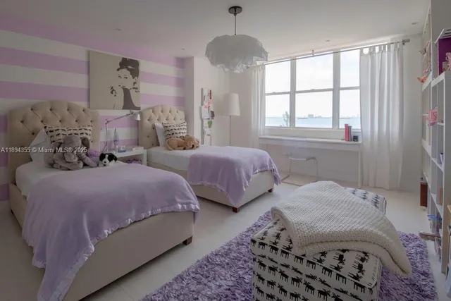 a bedroom with two beds and a window