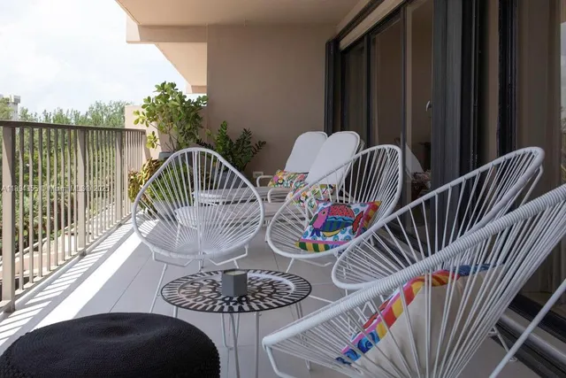 a view of a balcony with furniture and wooden floor