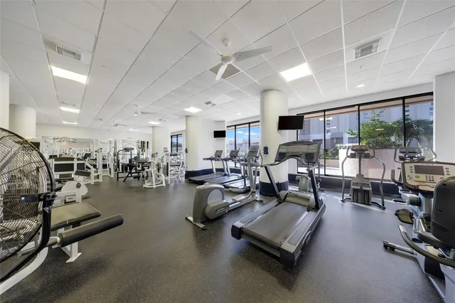 a gym room with lots of furniture and a window