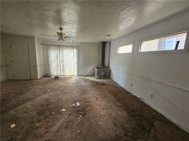 a view of a livingroom with a ceiling fan and window