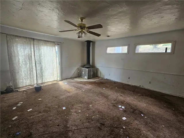 a view of a livingroom with a refrigerator a ceiling fan and wooden floor