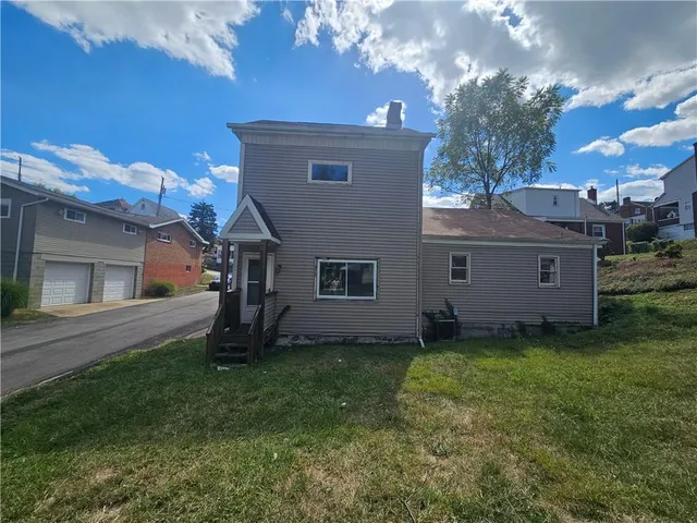 a view of a house with a yard and a tree