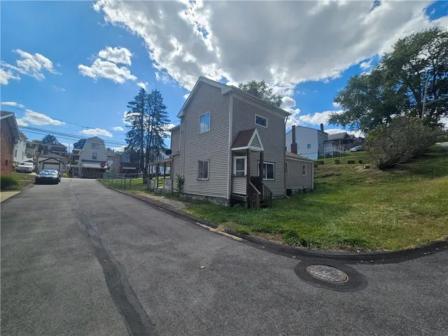 a backyard of a house with table and chairs