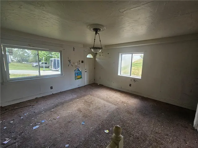 an empty room with windows and ceiling fan
