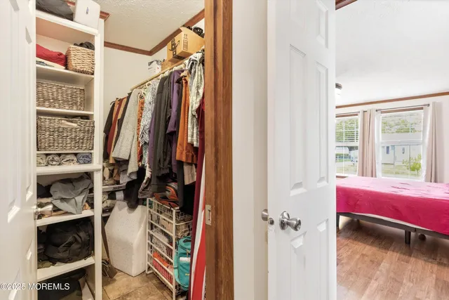 a view of walk in closet with clothes and shoes