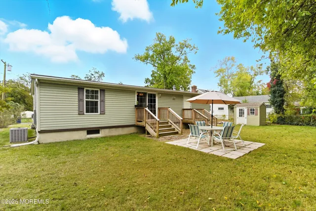 a view of a house with backyard and sitting area