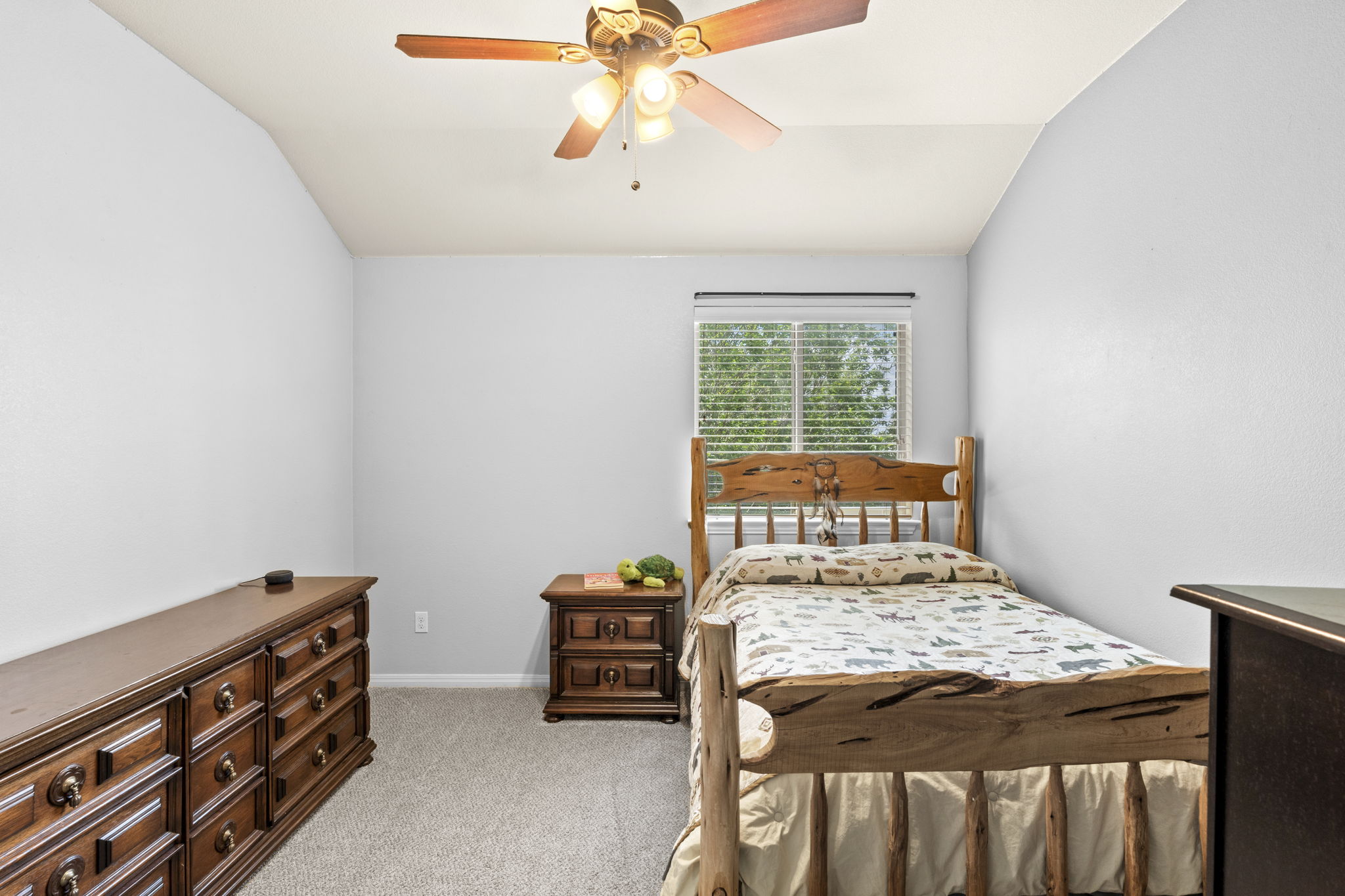 227 Sandstone Trail Buda, TX 78610 - Photo 18 of 33 Carpeted room featuring a window with blinds, a ceiling fan with light fixture, and vaulted ceilings