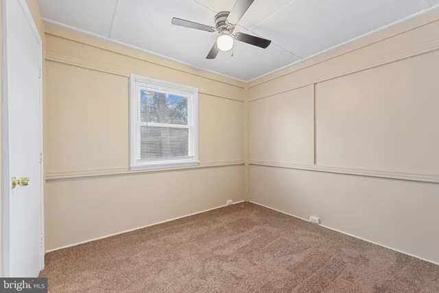 a view of empty room with ceiling fan