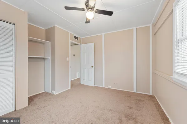 a view of empty room with windows and ceiling fan