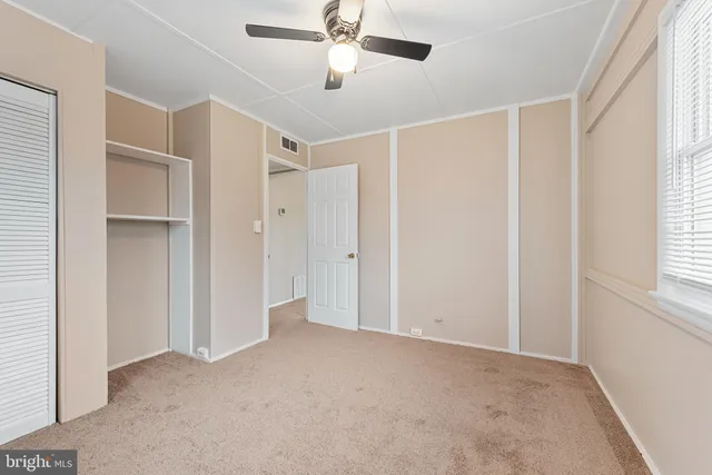 a view of empty room with windows and ceiling fan