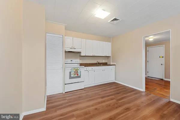 a kitchen with granite countertop white cabinets and white appliances