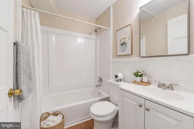 a bathroom with a granite countertop sink a toilet and a bathtub