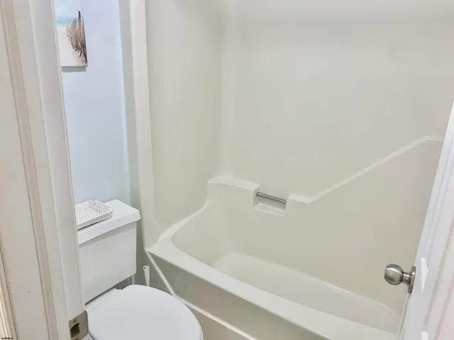 a white toilet sitting next to a bath tub
