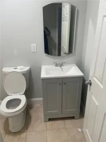 a bathroom with a toilet a sink and mirror