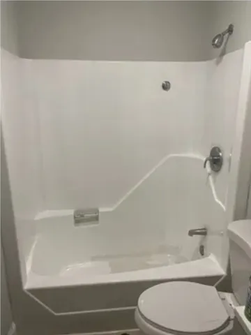a bathroom with a toilet and a bath tub