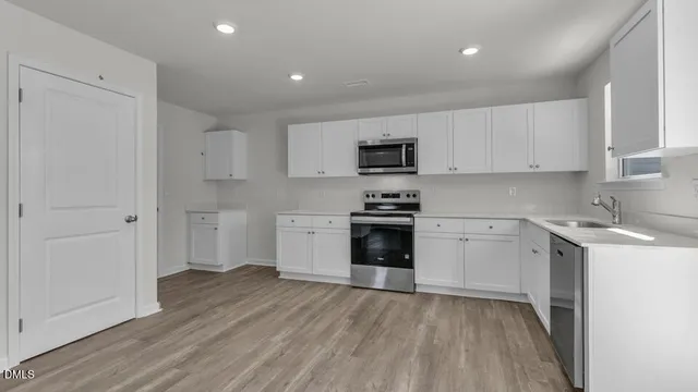 a kitchen with granite countertop white cabinets and stainless steel appliances