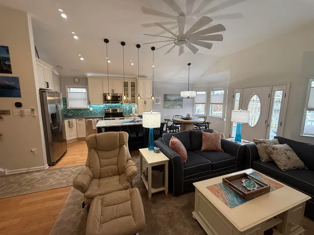 a living room with furniture a fireplace and a chandelier